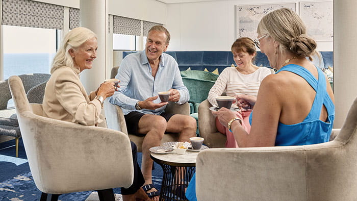 A group of people enjoying coffee in the Britannia Lounge on Spirit of Adventure